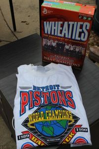 lot 262 image: Pistons Championship Wheaties cereal Box, unopened and Pistons Championship t-shirt