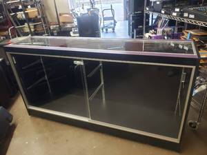 lot 357 image: Large Rolling Glass Display Case.  Includes 4 Glass Shelves (Not Pictured) Cabinet is Locked.  NO KEYS.