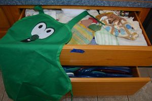 lot 85 image: Kitchen hand towels with Larry the Cucumber apron, plus plastic containers