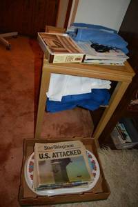 lot 294 image: Side table with contents - historic newspapers, cloth napkins, and placemats