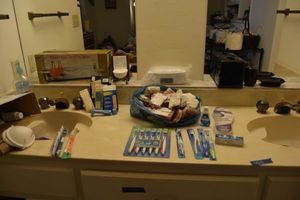 lot 485 image: Bathroom countertop contents - soaps, toothbrushes, black bathroom set, and more