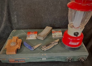 lot 173 image: Camping Equipment- Includes Coleman Stove, Knives, Whetstone , Fishing Tackle, Walkie Talkie Holster, and Battery Operated Coleman Latern