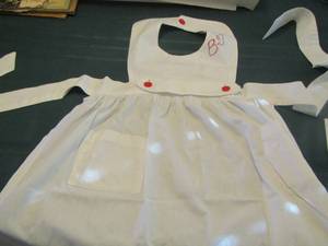 lot 151 image: white kitchen apron with the initials b.qj on it