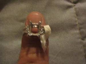 lot 561 image: womens silver in color ring has a broken blue rinestone in the box