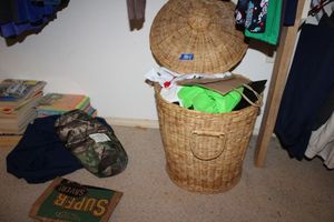 lot 555 image: Basket style laundry bin with shopping bags, Kids books, and puzzle books