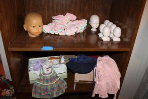 lot 71 image: Doll crafts Porcelain doll heads, one plastic doll head and clothes