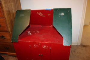 lot 90 image: Red and green wooden display cabinet on wheels