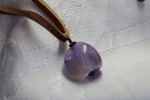 lot 343 image: Thick leather necklace with polished Amethyst silver wire pendant and Sterling Silver lobster clasp. Marked 925 on clasp. 16L and 2L