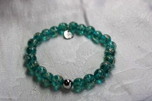 lot 348 image: Signed NOGU (Toronto, Canada) Sterling Silver Firefly Glass lampwork hand blown glass beads with phosphorescent particles (glows in dark after charged under light) stretch bracelet. Has NOGU 925 hang tag. Lifetime warranty by this company.