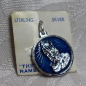 lot 379 image: Sterling Silver and enamel Spencers Praying Hands charm on card. Marked Sterling on reverse with Serenity prayer.1W