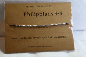 lot 380 image: Sterling Silver gift boxed Morse Code bracelet by Loved Creations with card and storage pouch. Morse code spells out Philippians 44 Rejoice in the Lord always, again I will say, Rejoice.