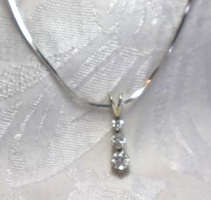 lot 381 image: Sterling Silver Past Present Future graduated CZ pendant (Marked 925) on silver finish 16L snake chain necklace. Lobster clasp. Pendant .75L