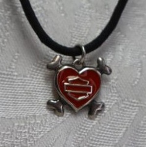 lot 395 image: Sterling Silver enamel Harley Davidson pendant with crossed bones on corded necklace with sterling lobster clasp. Marked 925 on clasp and on back of pendant. About 14L
