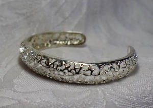lot 396 image: Sterling Silver filigree open cuff bracelet decorated with scroll and heart cutouts. Marked 925 inside.