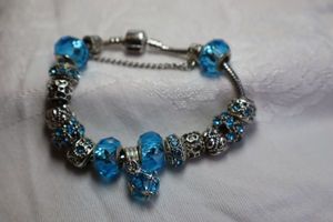 lot 397 image: Sterling Silver charm bracelet with blue crystal decorated beads and faceted blue glass sterling silver beads. 4 blue glass beads are marked 925.
