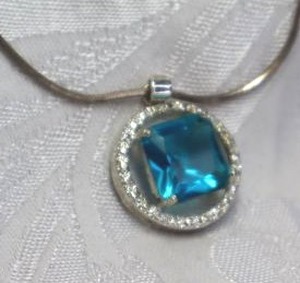 lot 401 image: Sterling Silver 18L snake chain necklace (Marked 925) with sterling silver faceted prong set glass pendant with rhinestone halo (marked 925). Pendant 1.25L