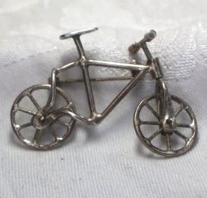 lot 408 image: Sterling Silver broochpin in bicycle form. Fully articulated. Marked 925 under seat. Wheels and handlebars move independently. 2W x 1.5H
