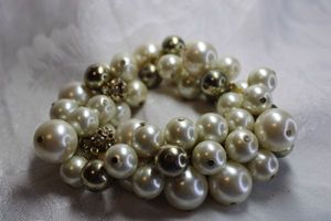 lot 429 image: Gold finish and faux pearl stretch bracelet with rhinestone decorated beads.