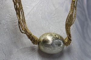 lot 428 image: Gold lam choker with large central cross hatched gold finish incorporated bead pendant. Spring ring clasp. 14L