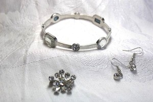 lot 483 image: Silver finish metal bangle bracelet with faceted crystal accents. Includes a pair of ear wire crystal earrings 1L and a swedged rhinestone pin