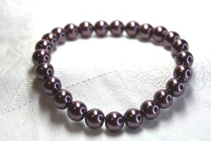 lot 460 image: Bronze color glass coated pearl stretch bracelet. Dark vivid bronze hue.
