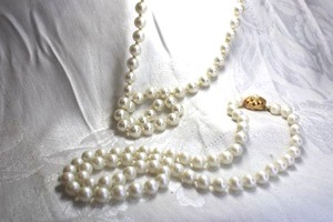 lot 503 image: (2) Faux pearl necklaces. One marked Japan with hook and eye covered clasp 24L and one with gold finish basketweave hidden clasp. 20L
