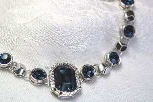 lot 530 image: Silver finish bracelet with faceted bezel set faux Blue Topaz glass stations and focal station with rhinestone halo. Lobster clasp. Adjustable from 7.5-9L