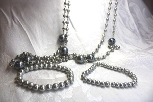 lot 542 image: Grey faux pearl jewelry. Includes a continuous necklace 58L and (20 faux gray pearl stretch bracelets.