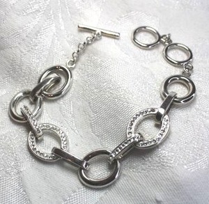 lot 550 image: Bright silver finish oval link and rhinestone accented toggle clasp bracelet. 8L