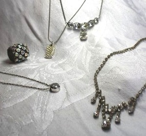 lot 566 image: (4) Silver finish rhinestone necklaces. (1) marked SP (Avon), (1) foil back dangle. Most about 16L. Includes a rhinestone AB slide bead.