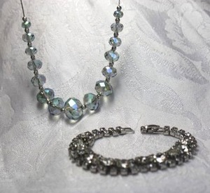 lot 568 image: (2) Silver finish rhinestone jewelry. Includes pale blue AB faceted rhinestone necklace 16L and a 7 rhinestone vintage bracelet with fold over clasp.