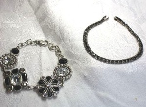 lot 569 image: (2) Black and clear silver finish bracelets. Flower station and tennis bracelet. Both 7L