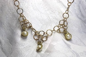 lot 571 image: Gold finish circle link necklace with wire wrapped pearl stations. 14L Toggle clasp.
