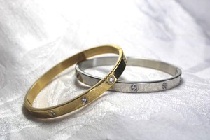 lot 578 image: (2) Tiffany style oval hinged bangles with crystal stations. Silver and gold.
