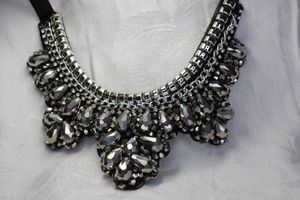 lot 426 image: Faceted black glass, rhinestone and chain half moon necklace with black satin fabric ties and felted back. Up to 34L