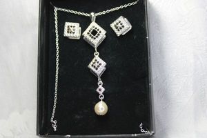 lot 504 image: Silver finish and enamel pearl pendant necklace and poststud earring set.