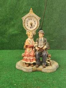 lot 81 image: Man and woman on Bench figurine clock