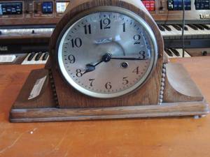 lot 25 image: Brown mantel clock , needs foot repairs