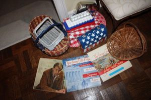 lot 72 image: Red, White and Blue lot Albums, baskets lunch pail, ice molds, apron, tablecloth, placemats and extra blue fabric