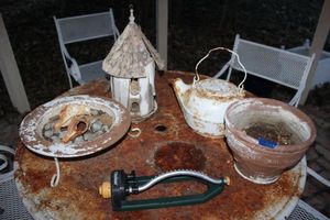 lot 637 image: Garden decorations, planter and sprinkler attachment