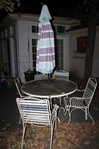 lot 672 image: Patio table and chairs with umbrella. Wrought iron frames.