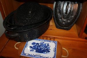 lot 268 image: Three Black Speckled Enamel Painted Roasting Pans, Two have Lids, and Delft Style Had Painted Tile Trivet
