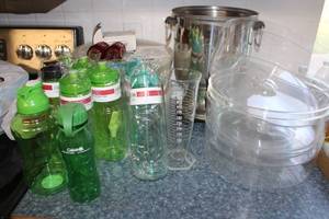 lot 37 image: Misc. lot drink dispensers, glass measuring cup, red glass shakers, water bottles, and plastic cake lids
