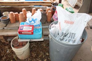 lot 562 image: Metal trash can with pearlite, potting mix and flower pots