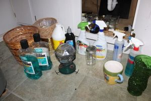 lot 91 image: Household cleaners and trash baskets, hummingbird feeder, and vases