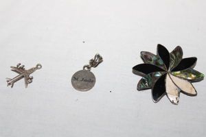 lot 177 image: Jewelry Sterling silver - mother of pearl pin, St. Jude pendant, and Air plane pendant
