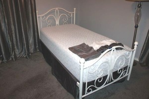 lot 28 image: Twin size bed frame. Features a white metal frame and mattress is available