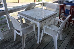 lot 277 image: Patio table with tile top and plastic white chairs