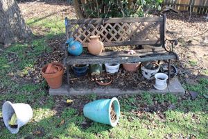 lot 263 image: Cast iron garden bench (needs new boards) and flower pots