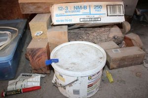 lot 318 image: Misc. wood chunks, concrete patcher, and tote